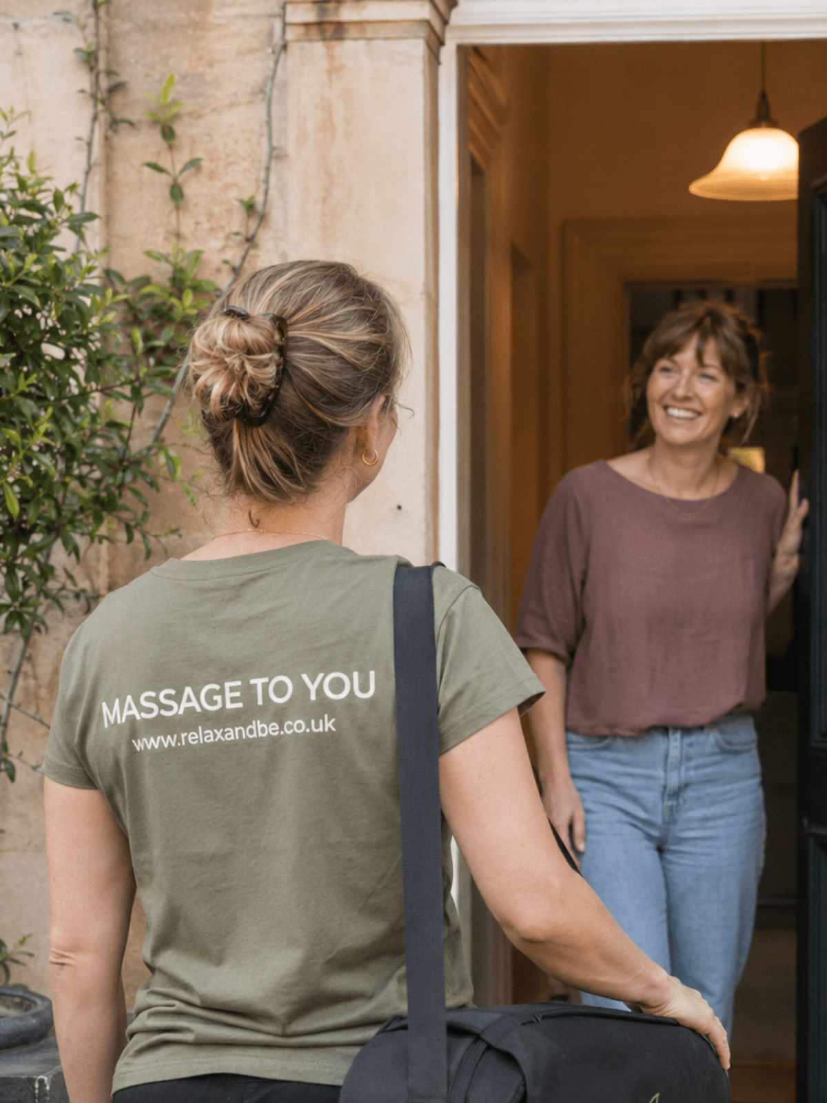 Female mobile massage therapist arriving at a client's home with her portable massage table