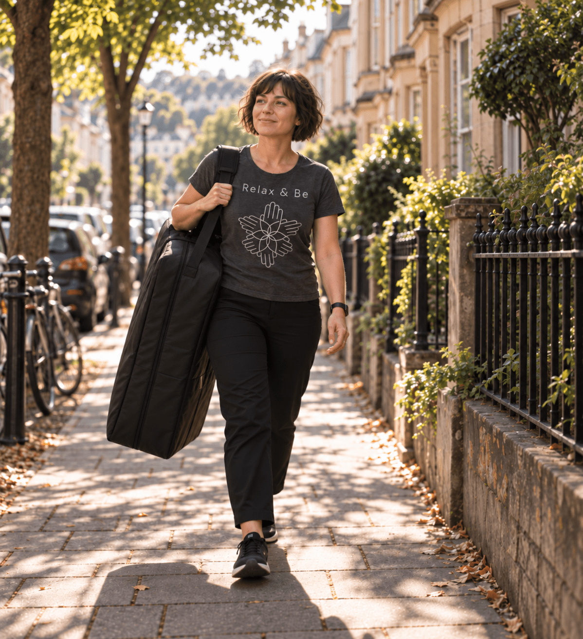Relax & Be therapist walking forward carrying a massage table